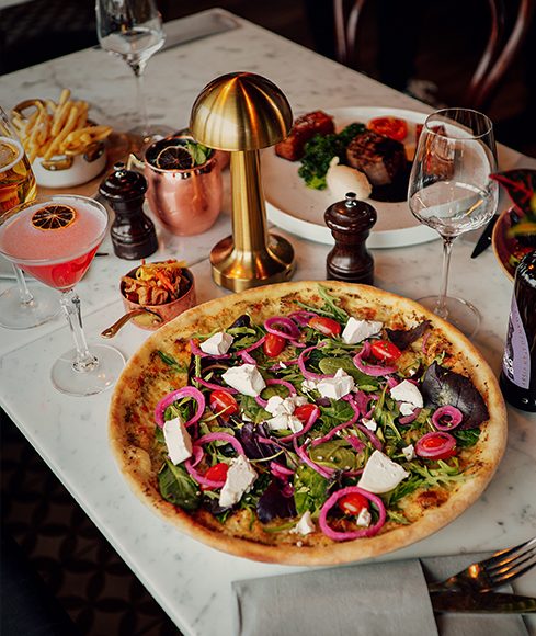 Dukat bord med pizza, glas och pepparkvarnar i restaurangens matsal